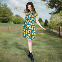 Woman in a floral breastfeeding dress standing in a grassy field with trees in the background