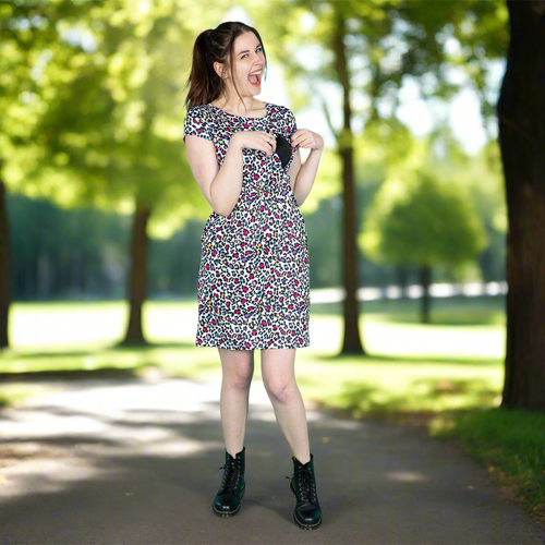 Woman in a floral breastfeeding dress standing in a park showing the secret breastfeeding access